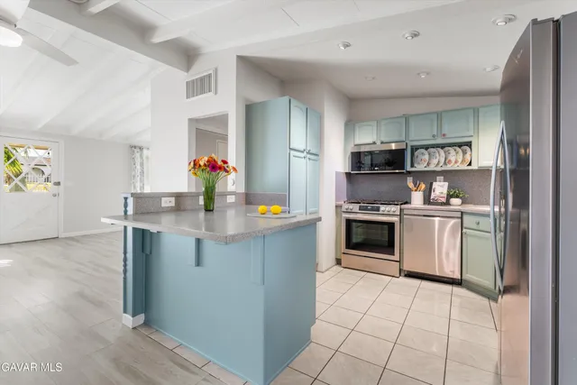 a kitchen with stainless steel appliances granite countertop a refrigerator and a stove top oven