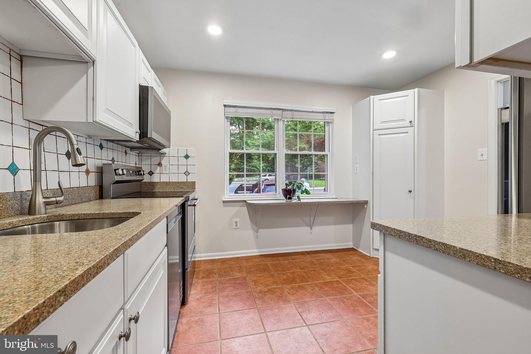 11714 Dry River Court Reston, VA 20191 - Photo 20 of 24 a kitchen with stainless steel appliances granite countertop a sink and a refrigerator