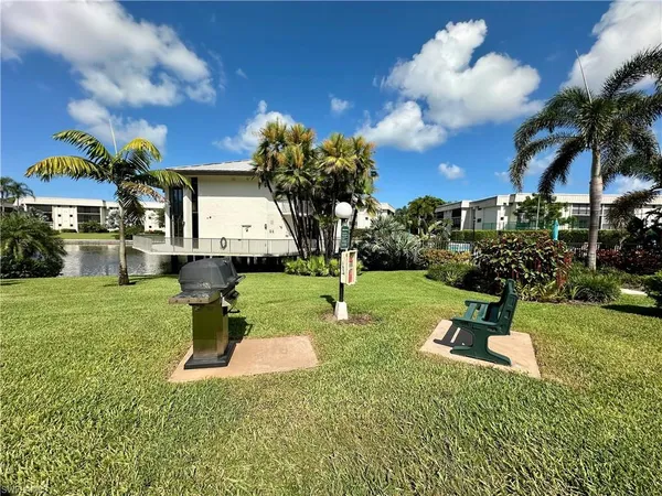 a front view of a house with a yard fountain and large tree