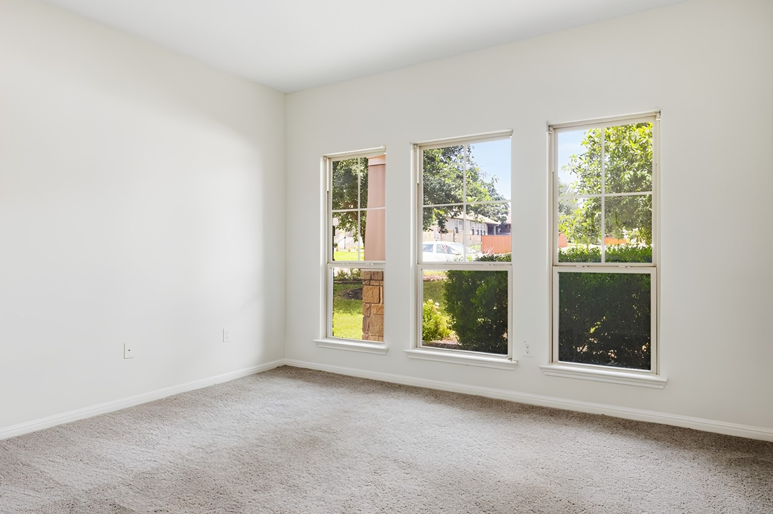 304 Santa Maria Street Georgetown, TX 78628 - Photo 11 of 37 Three large windows illuminate this inviting room, showcasing verdant outdoor views.