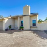 a front view of a house with a yard and potted plants