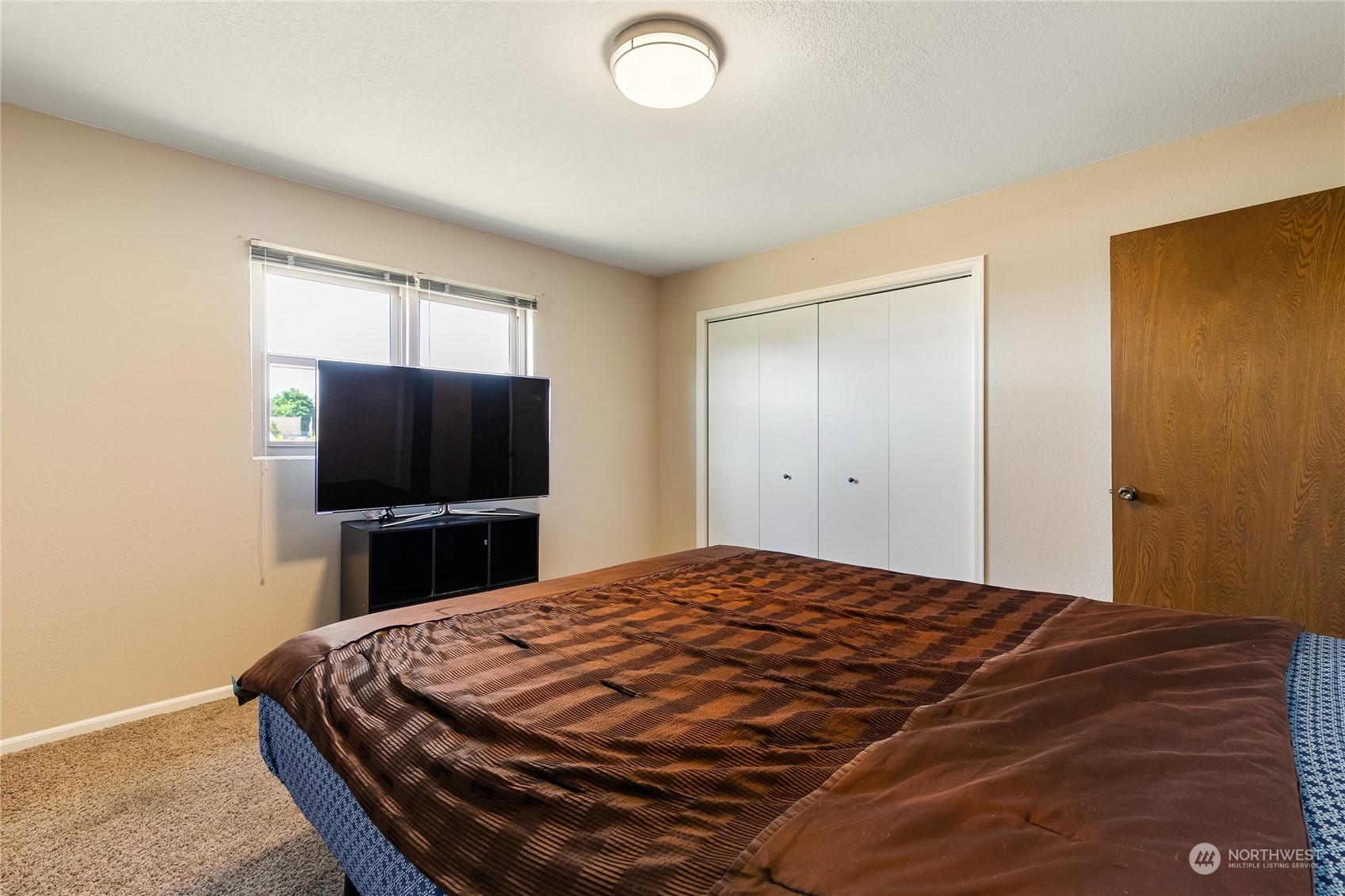 1520 East Badger Road Lynden, WA 98264 - Photo 21 of 36 a bedroom with a bed and a flat screen tv