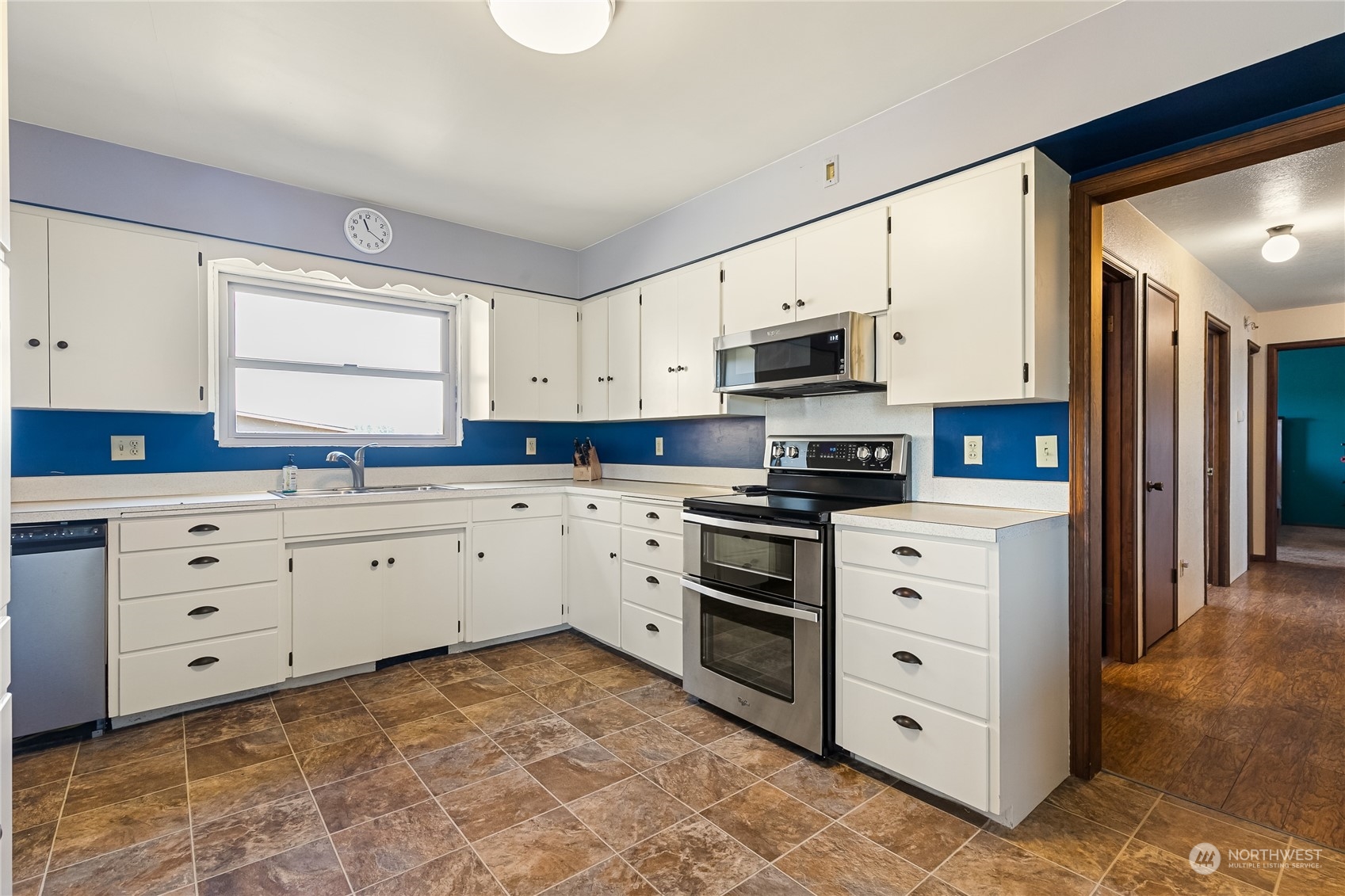 1520 East Badger Road Lynden, WA 98264 - Photo 10 of 36 a kitchen with granite countertop white cabinets and stainless steel appliances