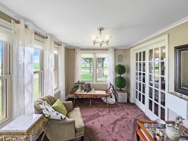 a living room with furniture a fireplace and a floor to ceiling window