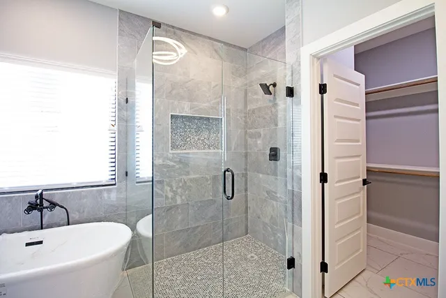 a bathroom with a tub shower and sink