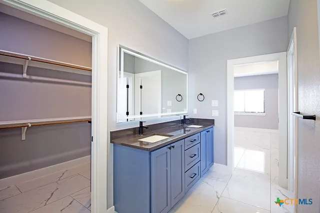 a bathroom with a granite countertop sink and a mirror