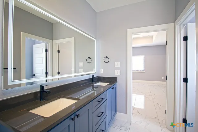 a spacious bathroom with a granite countertop sink and a mirror