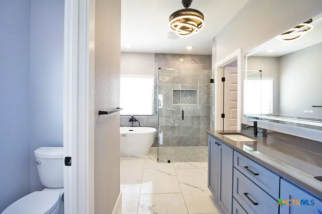 a spacious bathroom with a granite countertop sink and a large mirror