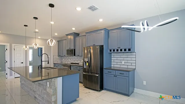 a kitchen with kitchen island a counter top space appliances and a ceiling fan