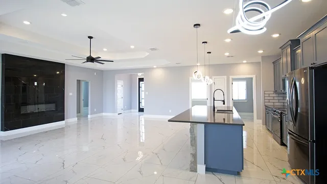 a kitchen with stainless steel appliances kitchen island a refrigerator and a sink