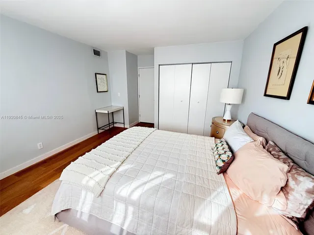 a bedroom with a bed and painting on the wall