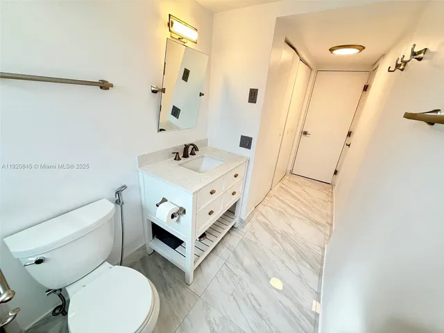 a bathroom with a sink a toilet a mirror and shower