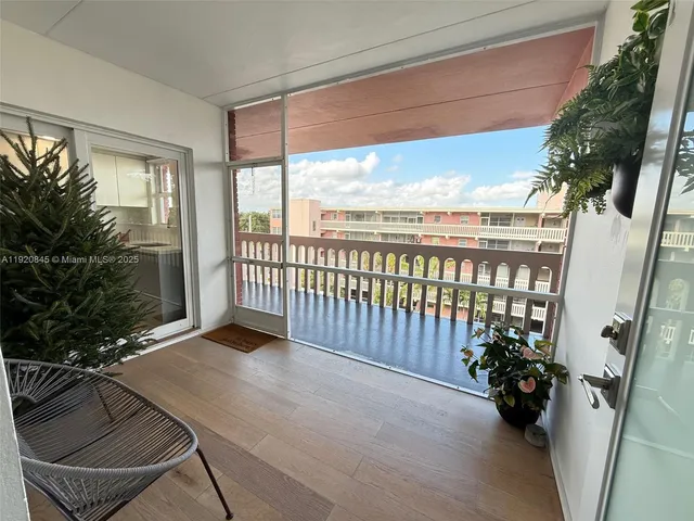 a view of a porch with furniture and floor to ceiling window