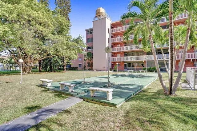 a view of a house with a yard and palm trees