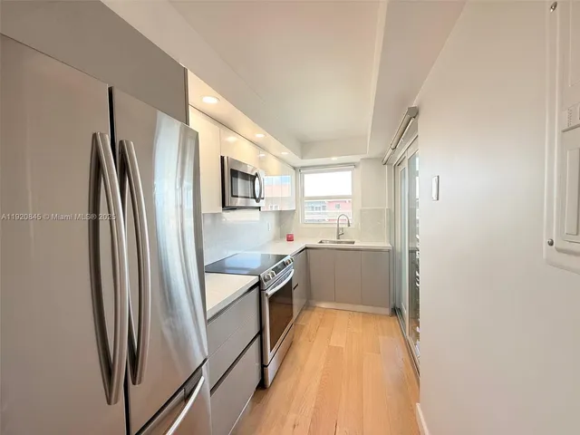 a kitchen with stainless steel appliances granite countertop a refrigerator and a sink
