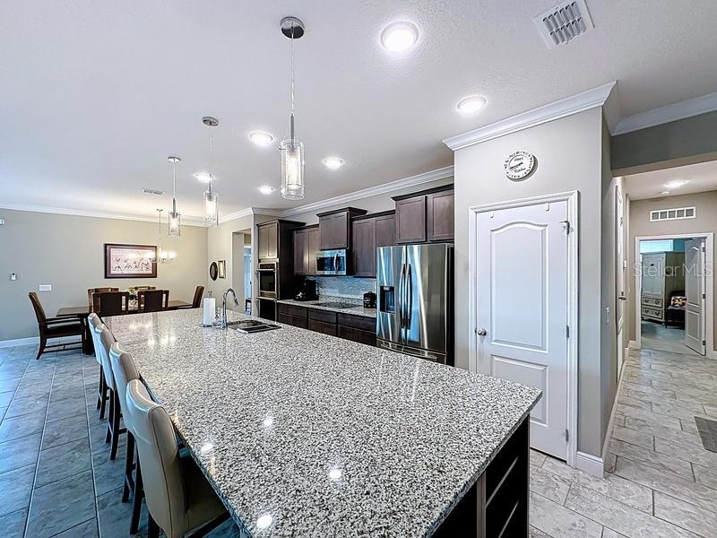 10148 Florence Ridge Drive Clermont, FL 34711 - Photo 13 of 50 a kitchen with stainless steel appliances granite countertop a table chairs sink refrigerator and microwave