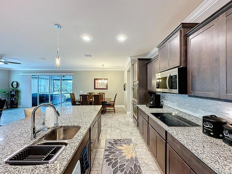 10148 Florence Ridge Drive Clermont, FL 34711 - Photo 16 of 47 a kitchen with stainless steel appliances granite countertop a sink stove microwave and refrigerator