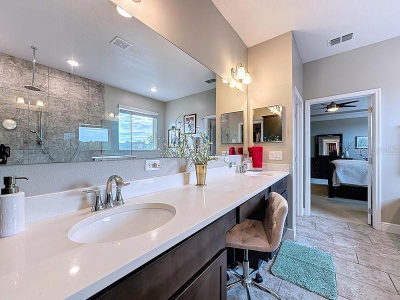 10148 Florence Ridge Drive Clermont, FL 34711 - Photo 22 of 47 a bathroom with sinks a vanity and a large mirror