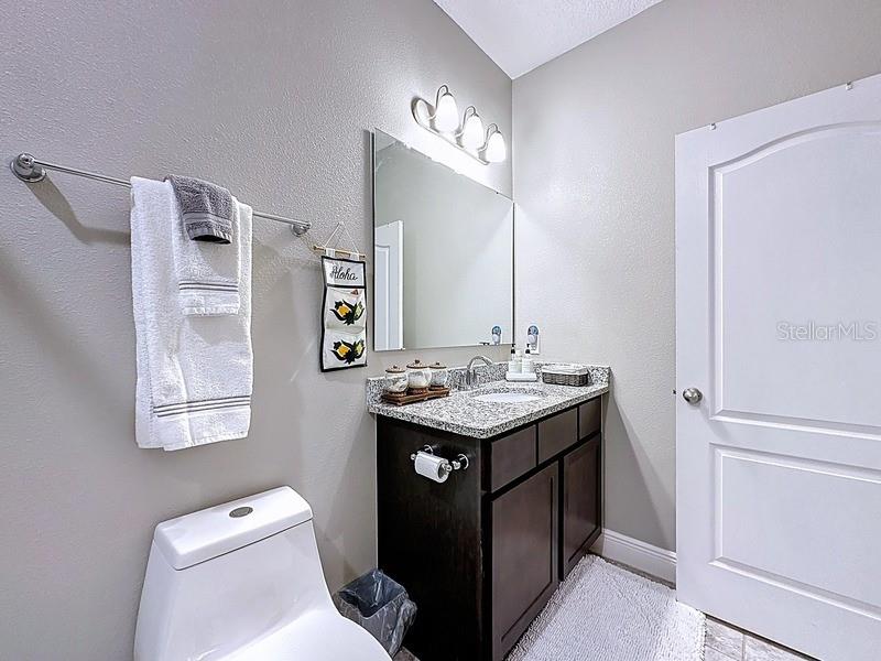 10148 Florence Ridge Drive Clermont, FL 34711 - Photo 34 of 47 a bathroom with a granite countertop sink toilet and mirror