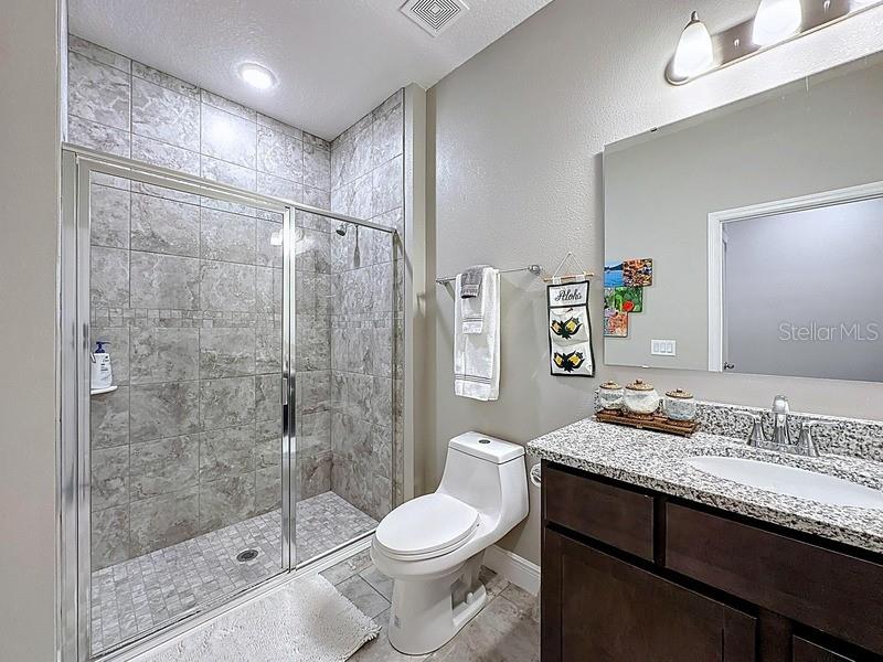 10148 Florence Ridge Drive Clermont, FL 34711 - Photo 35 of 47 a bathroom with a granite countertop sink toilet and shower