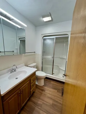 a bathroom with a granite countertop sink toilet and mirror
