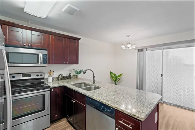 a kitchen with stainless steel appliances granite countertop a sink refrigerator and microwave