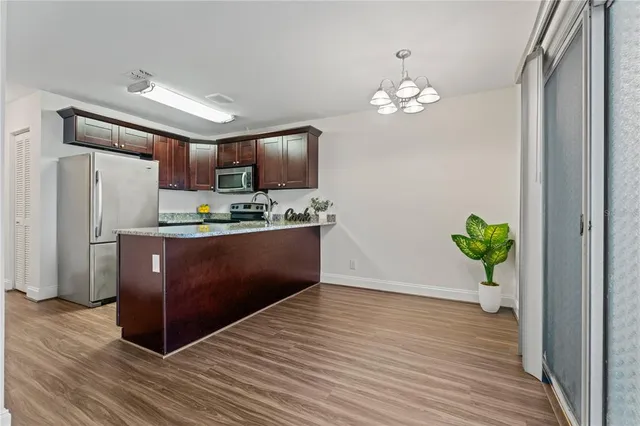 a kitchen with kitchen island stainless steel appliances a refrigerator sink and stove