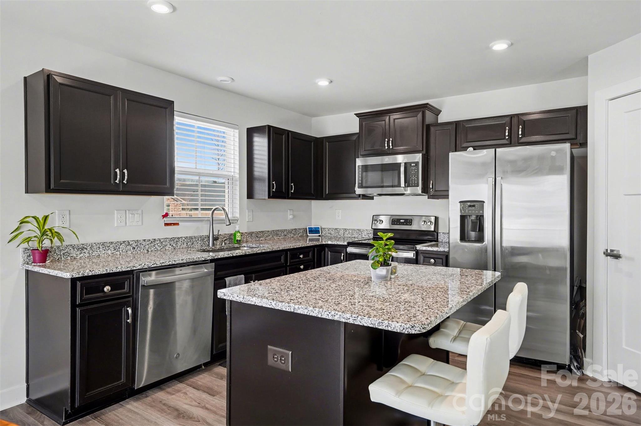 621 Grandiflora Avenue Lancaster, SC 29720 - Photo 14 of 37 a kitchen with granite countertop kitchen island stainless steel appliances a refrigerator sink stove microwave and cabinets