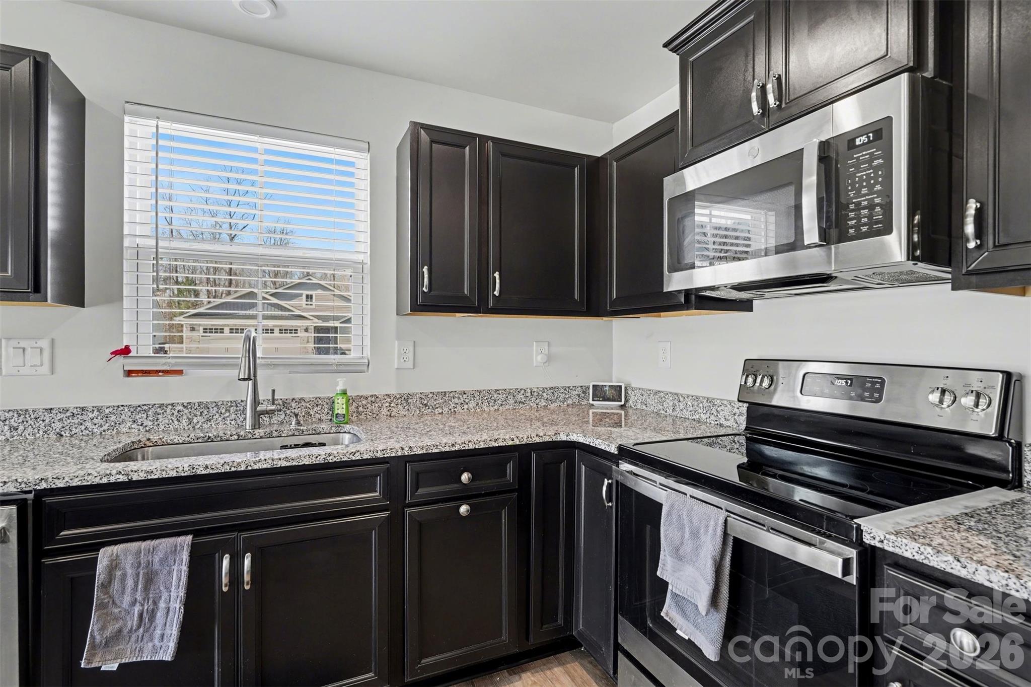 621 Grandiflora Avenue Lancaster, SC 29720 - Photo 17 of 37 a kitchen with granite countertop a sink stove and microwave