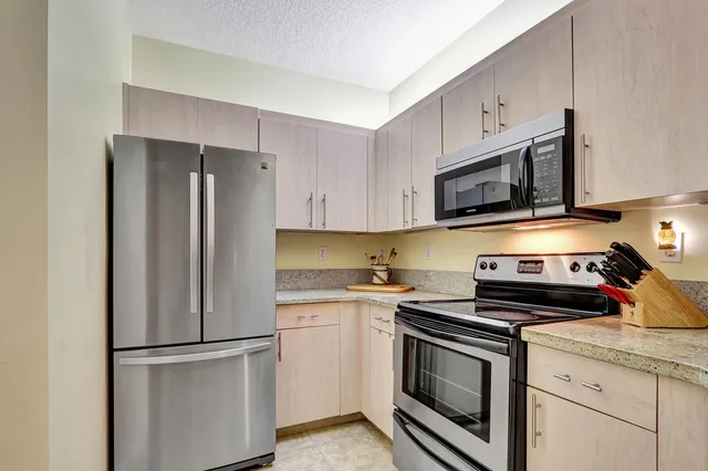 a kitchen with cabinets stainless steel appliances and wooden floor