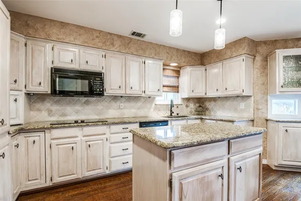 a kitchen with granite countertop white cabinets white stainless steel appliances and a sink