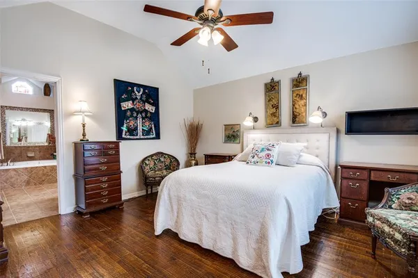 a bedroom with bed and wooden floor