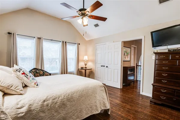 a bedroom with a bed and a flat tv screen on dresser
