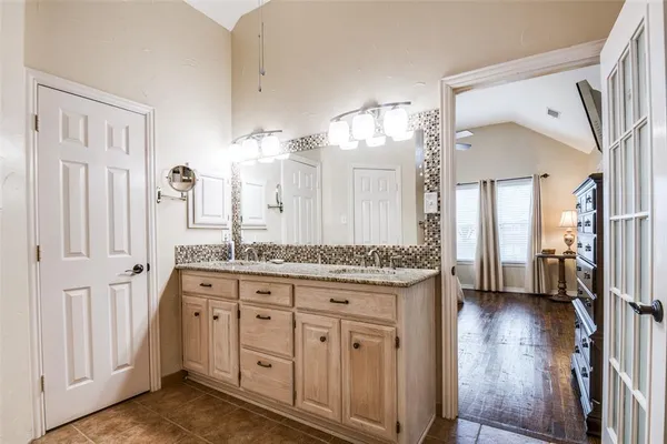 a bathroom with a granite countertop sink a mirror and a shower