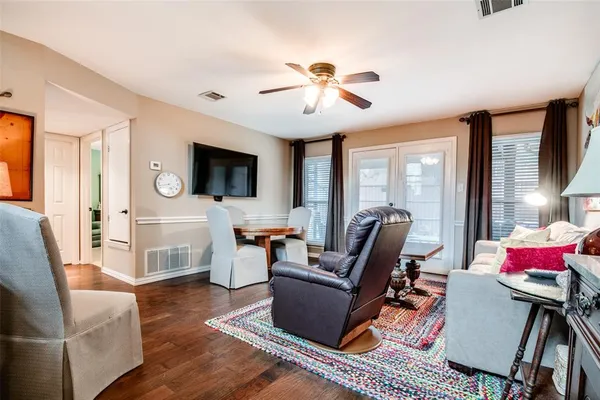 a living room with furniture a flat screen tv and large window
