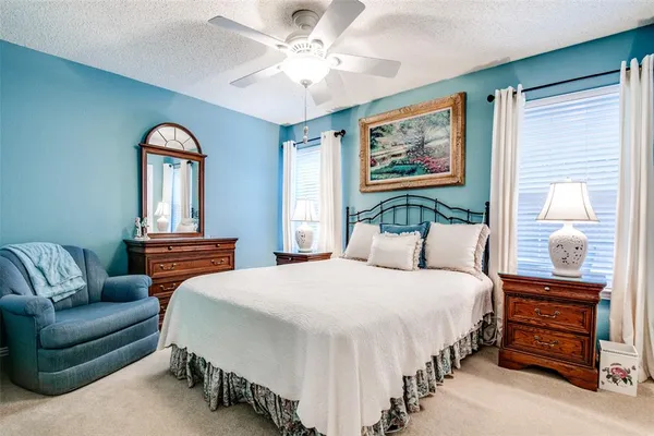 a bedroom with a bed and dresser with mirror