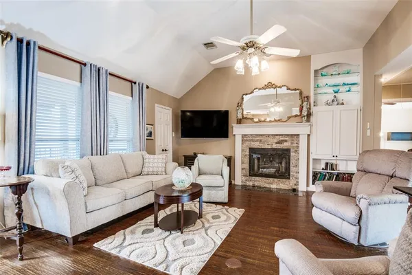 a living room with furniture a fireplace and a flat screen tv