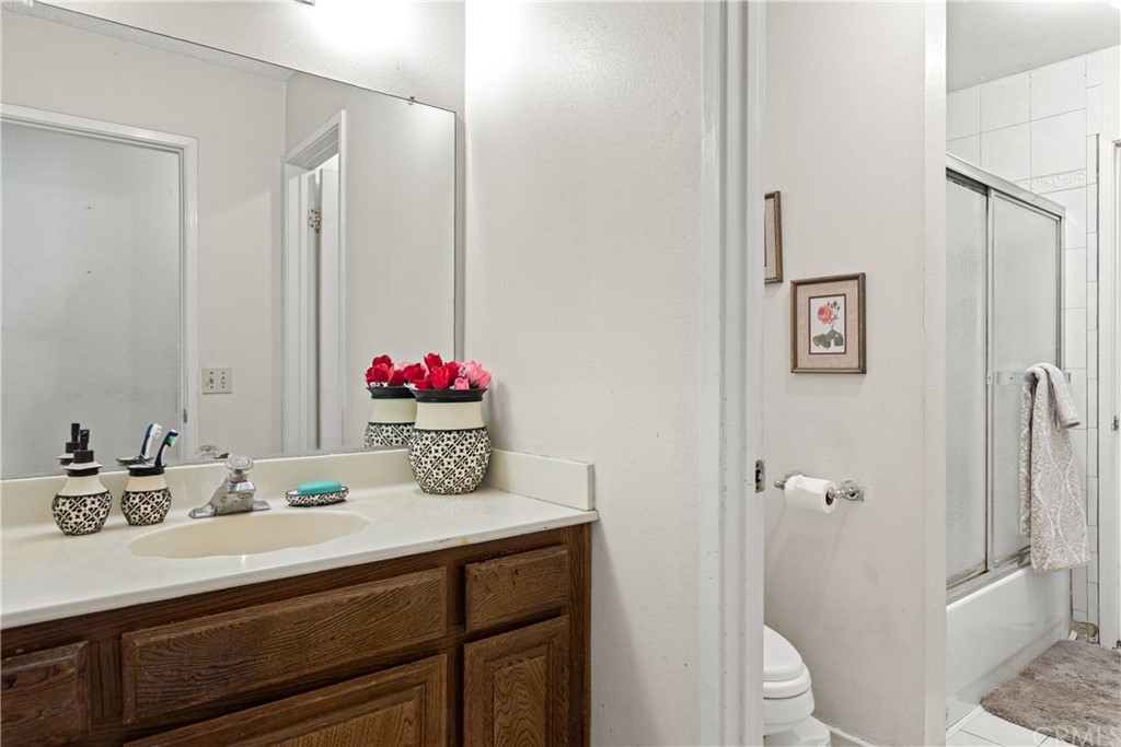 16874 Donwest, Unit 75 Tustin, CA 92780 - Photo 18 of 23 a bathroom with a granite countertop sink mirror and toilet