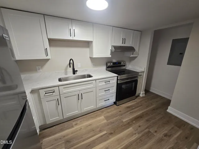 a kitchen with a stove sink and cabinets