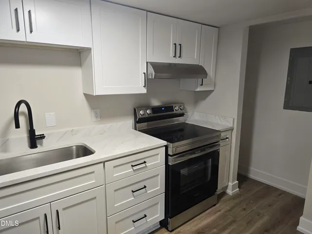 a kitchen with sink a stove and cabinets