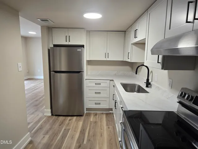 a kitchen with a refrigerator a sink and cabinets