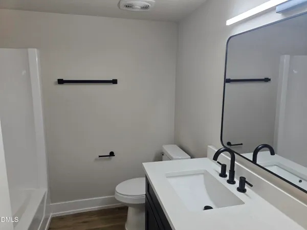 a bathroom with a sink a toilet and a mirror