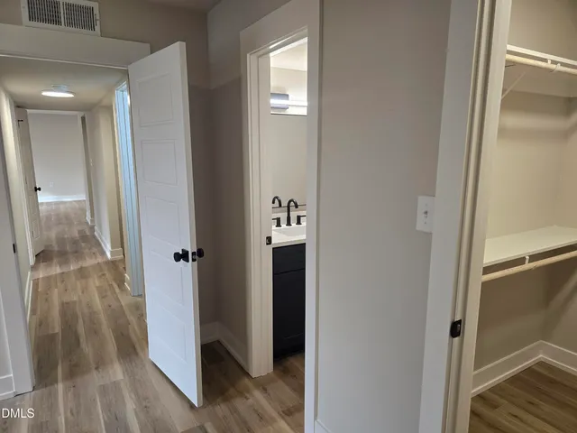 a view of a hallway with wooden floor and staircase