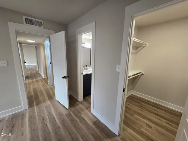 a view of a hallway with wooden floor and staircase