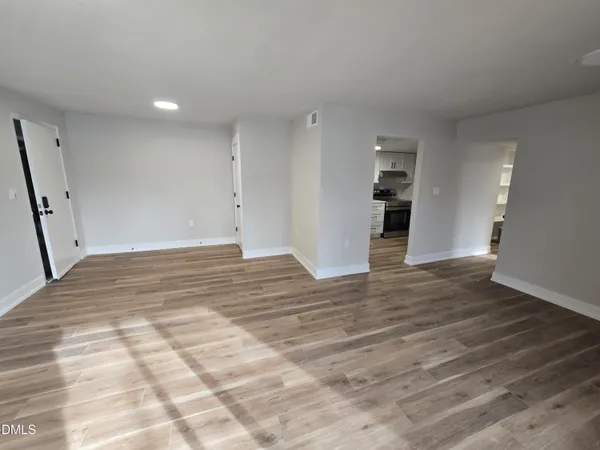 a view of empty room with wooden floor