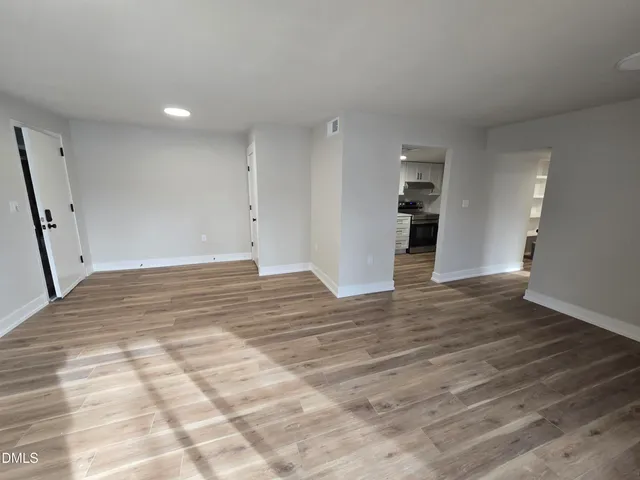 a view of empty room with wooden floor