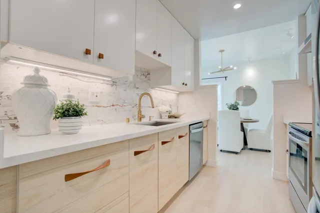 a kitchen with kitchen island white cabinets and white appliances