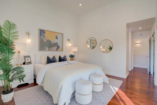 a spacious bedroom with a bed and a potted plant