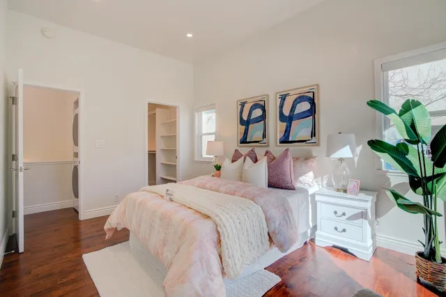 a bedroom with a large bed and a potted plant