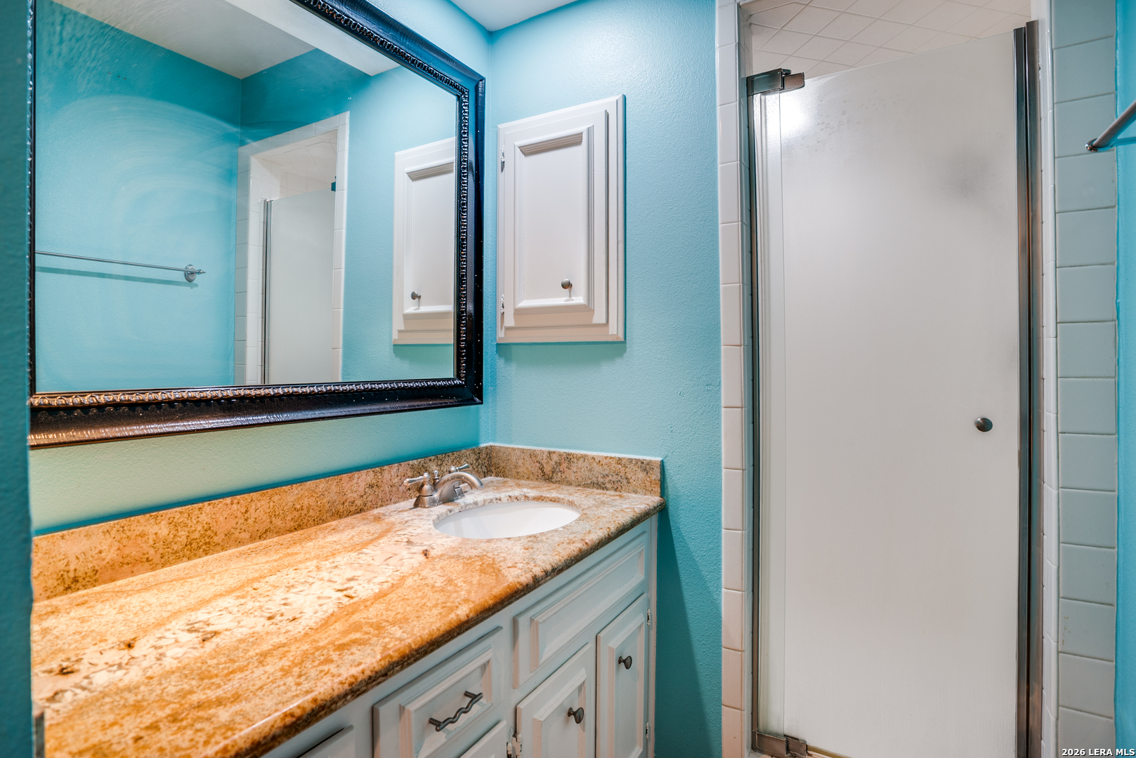 5359 Fredericksburg, Unit 515 San Antonio, TX 78229 - Photo 23 of 25 a bathroom with a granite countertop sink and a large mirror